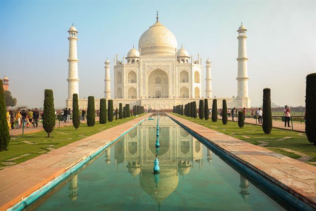 Taj Mahal's white marble dome and minarets reflected in the long garden pool in Agra