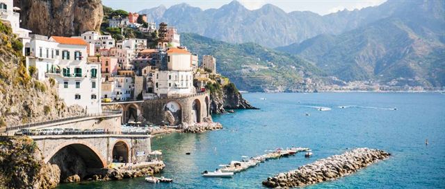 Colorful cliffside village and arched seafront bridge on the Amalfi Coast, Italy