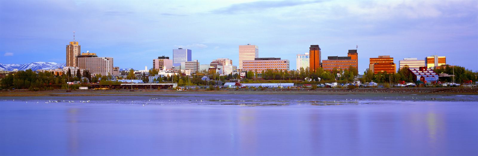 Downtown Anchorage skyline across the water with snowy Chugach Mountains behind, Alaska