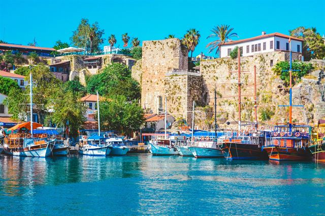 Antalya's Kaleiçi old harbor with gulets, stone Roman-era walls, palms and Ottoman houses above