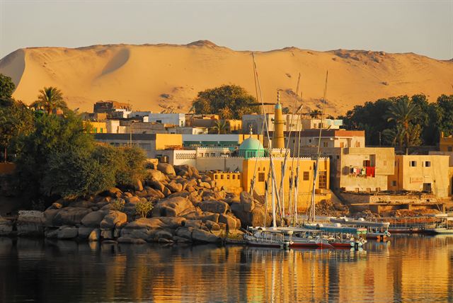 Nubian village houses and granite rocks on the Nile at Aswan in golden light