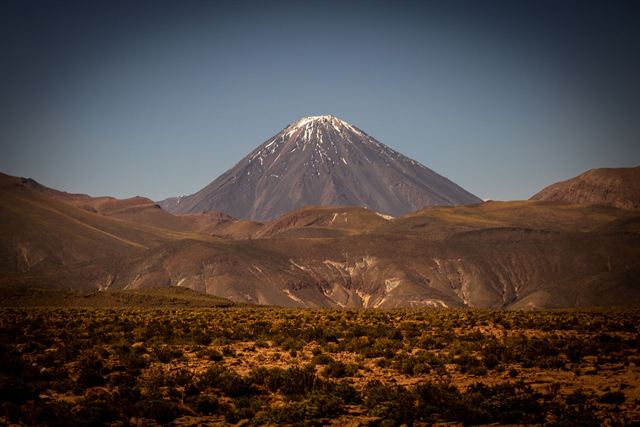 Snow-capped Licancabur volcano rising above desert scrub near San Pedro de Atacama, Chile