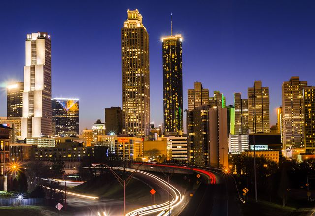 Atlanta skyline at night with lit towers and light trails on the downtown connector freeway