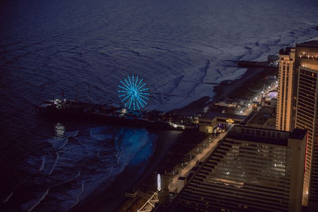 Aerial night view of the Atlantic City boardwalk, Steel Pier and its illuminated blue Ferris wheel