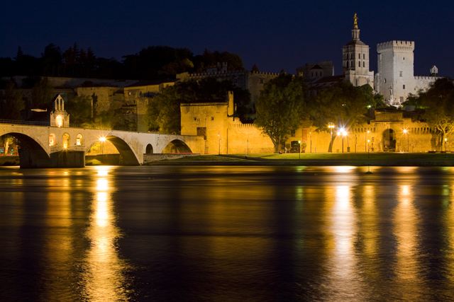 Pont d'Avignon and the Palais des Papes lit up at night over the Rhone