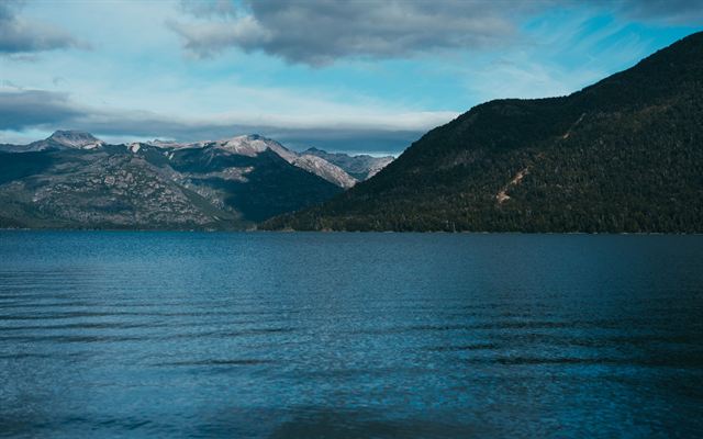 Deep blue Lake Nahuel Huapi beneath forested slopes and distant mountains at Bariloche