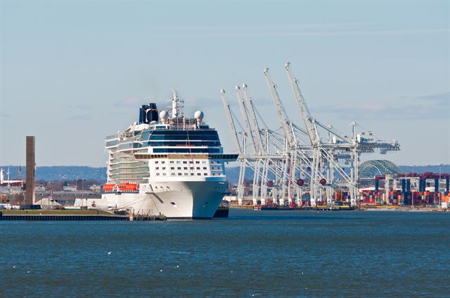 Celebrity cruise ship moored at Cape Liberty Cruise Port beside cargo cranes in Bayonne, New Jersey