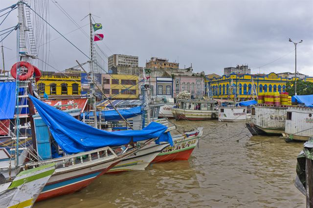Colorful fishing boats moored in front of old waterfront buildings at the port of Belém, Brazil