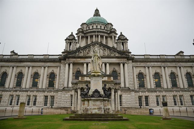 Belfast City Hall's domed Baroque Revival facade with Queen Victoria statue and front lawn