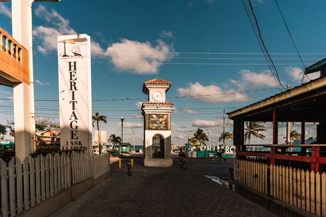 Heritage Bank and the Welcome to San Pedro clock monument on a street in San Pedro, Ambergris Caye, Belize