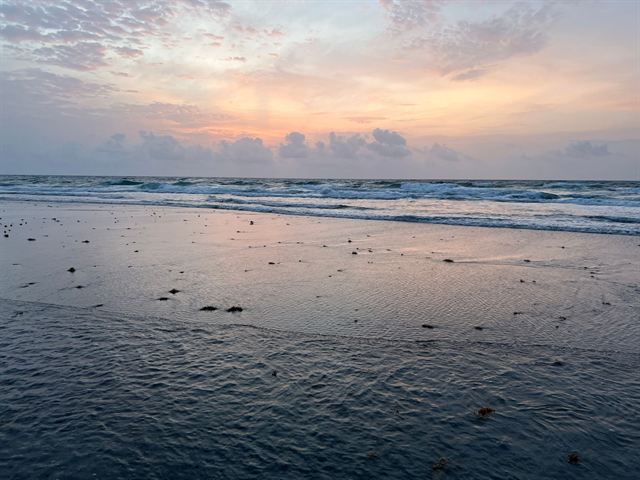 Gentle waves on the beach at Boca Raton, Florida at sunset under a pastel sky