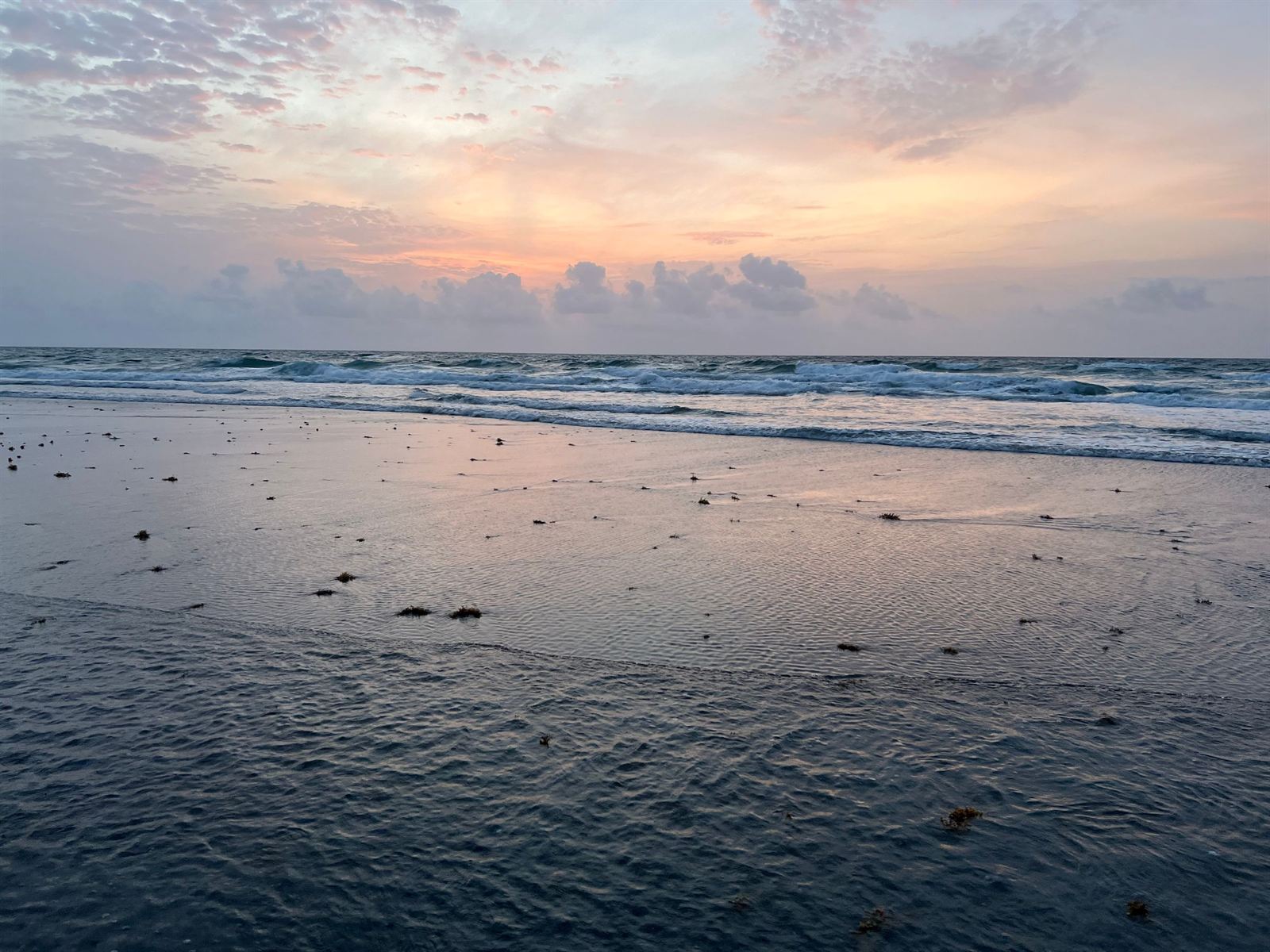 Gentle waves on the beach at Boca Raton, Florida at sunset under a pastel sky