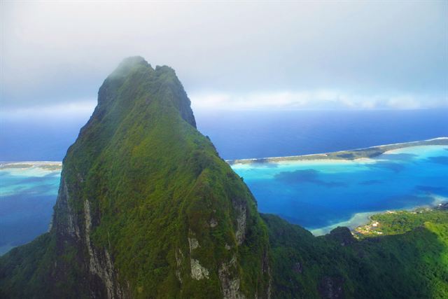 Aerial view of Mount Otemanu peak on Bora Bora with the turquoise lagoon and reef motu