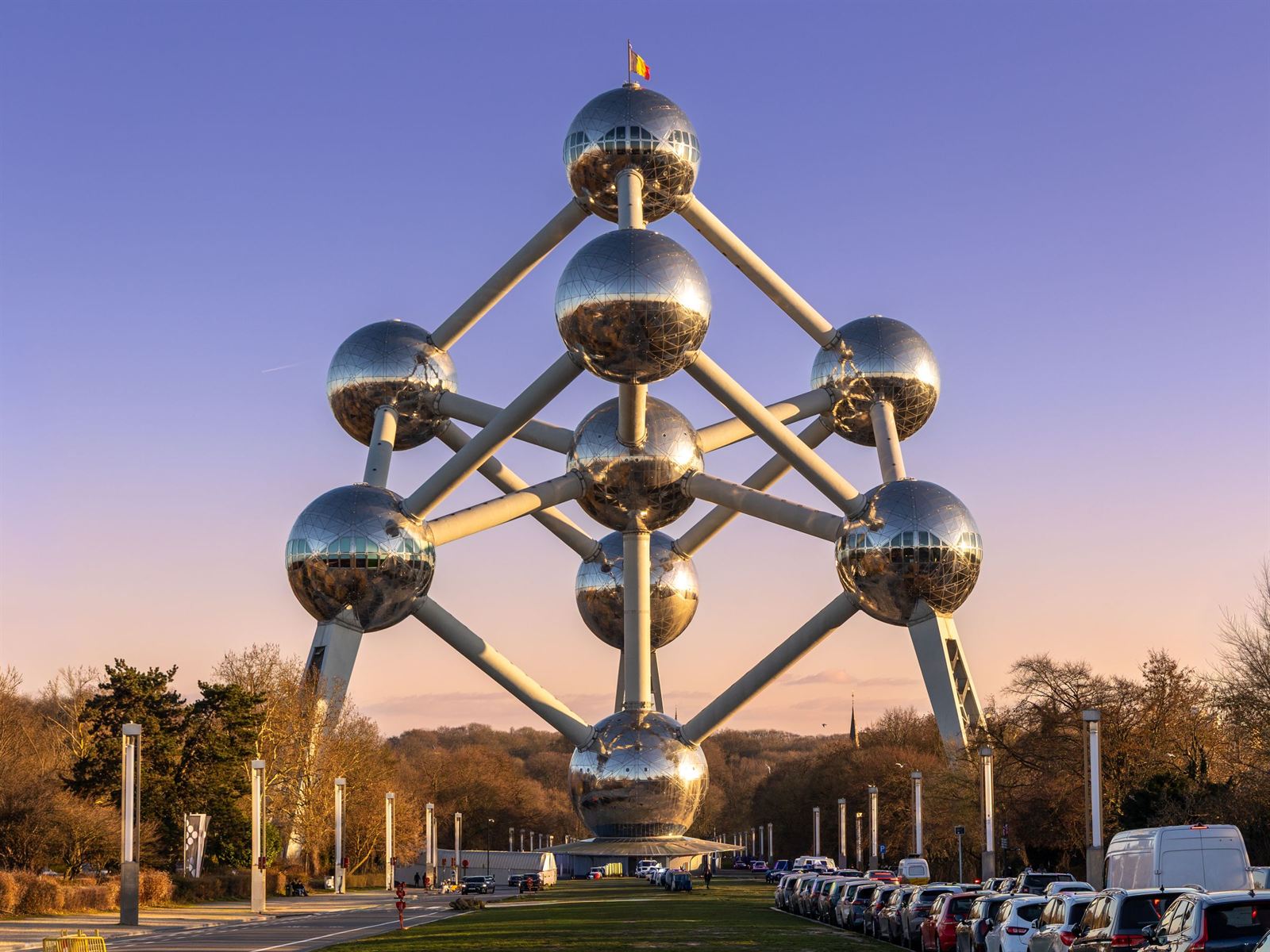 The Atomium's giant steel spheres in Brussels against a pink and purple sunset sky