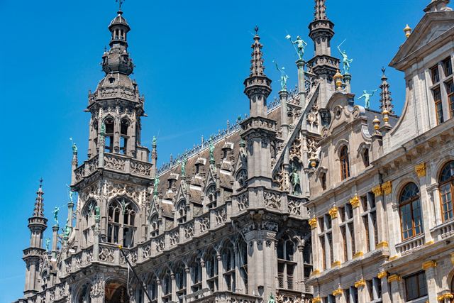 Ornate neo-Gothic Maison du Roi (Brussels City Museum) spires on the Grand Place under blue sky
