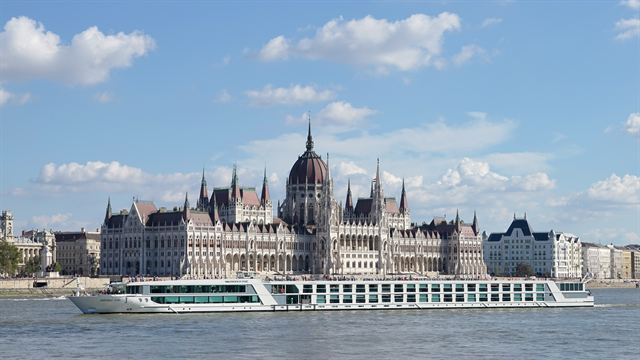 River cruise ship passing the domed Hungarian Parliament on the Danube in Budapest