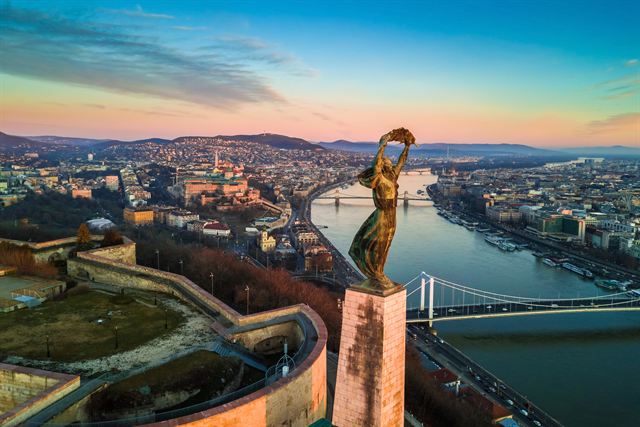 Liberty Statue on Gellert Hill overlooking the Danube bridges and Budapest at sunset