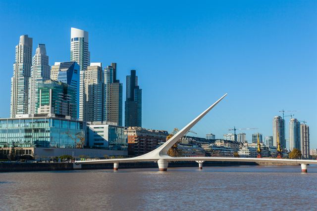 Puente de la Mujer footbridge and Puerto Madero glass towers under a blue sky, Buenos Aires
