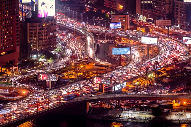 Cairo at night with heavy traffic on elevated highways between lit buildings