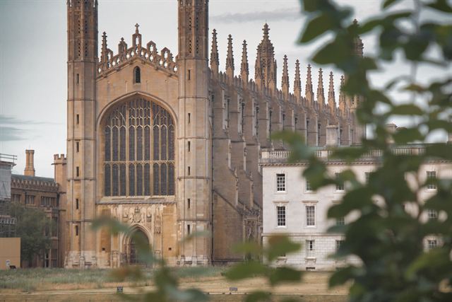 Gothic west end of King's College Chapel in Cambridge framed by leaves
