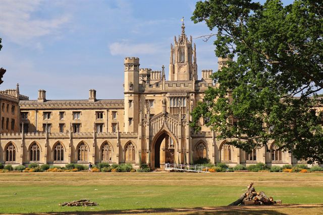 St John's College, Cambridge, honey-stone gatehouse tower and ranges beyond a sunny lawn