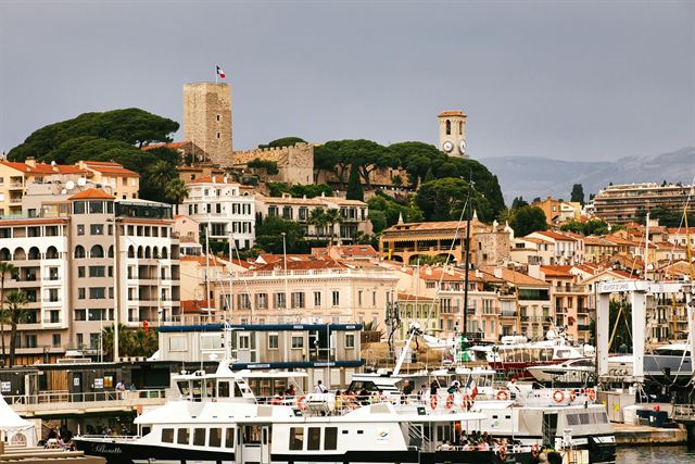 Le Suquet old town of Cannes with its castle tower and church above the Old Port yachts