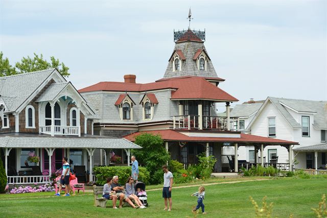 Victorian gingerbread cottages with families on a lawn at Oak Bluffs, Martha's Vineyard