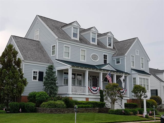 Gray Victorian-style house with a porch and patriotic bunting in Cape May, New Jersey