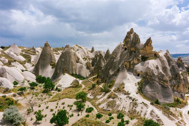 Cappadocia's fairy chimney rock formations in a valley near Göreme under cloudy sky