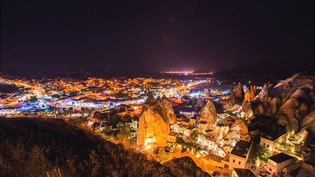 Göreme town in Cappadocia lit up at night among illuminated rock formations