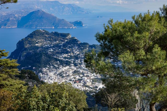 View over Capri town and the island's green slopes toward the Sorrento peninsula across the sea