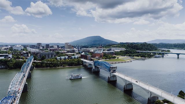 Aerial view of the blue Walnut Street Bridge over the Tennessee River with downtown Chattanooga and Lookout Mountain