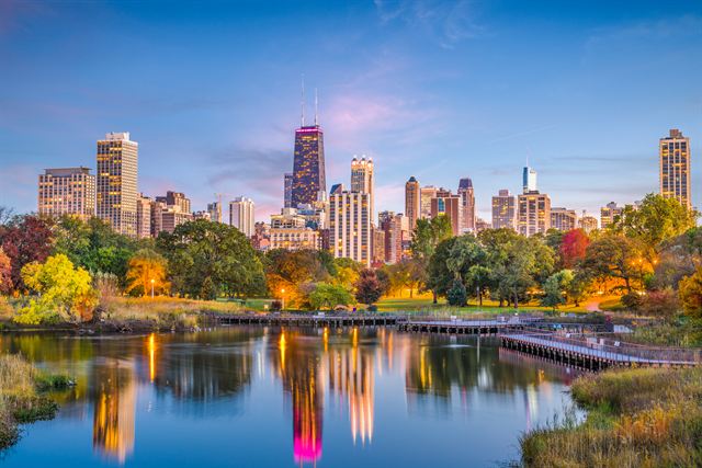 Chicago skyline reflected in the Lincoln Park lagoon with autumn trees at dusk