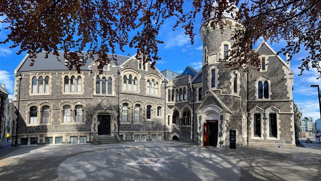 Gothic Revival grey-stone Arts Centre buildings in Christchurch under autumn foliage