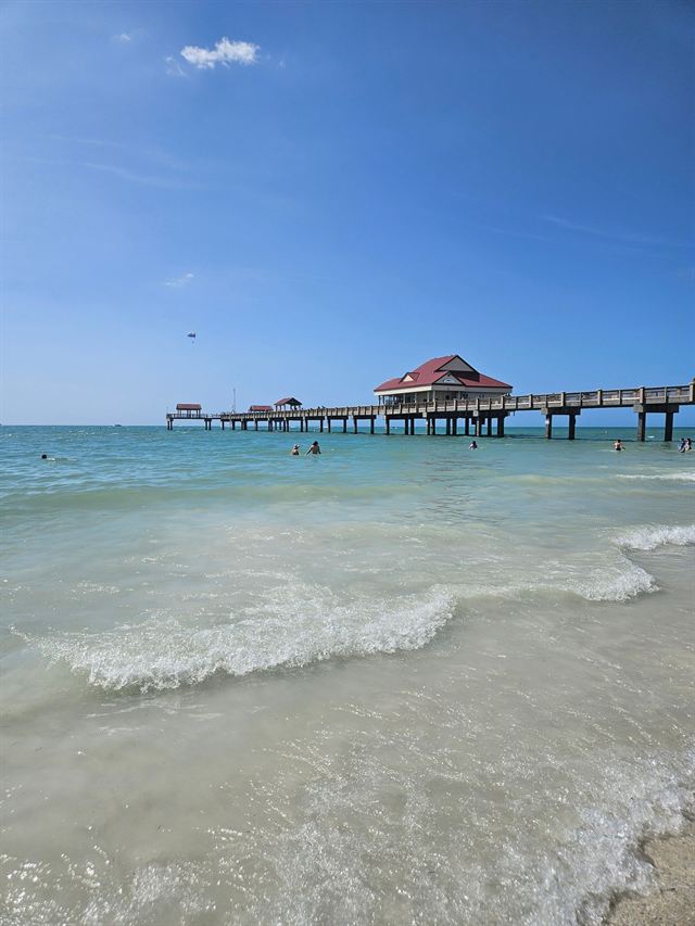 Pier 60 extending over clear turquoise shallows at Clearwater Beach on a sunny day