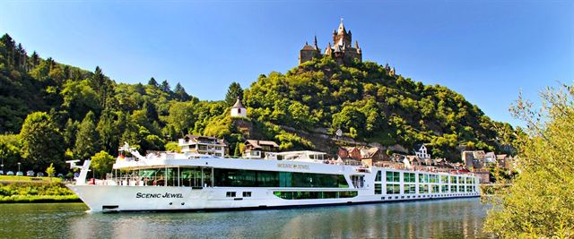 Scenic river cruise ship moored below Cochem's Reichsburg castle on the Moselle