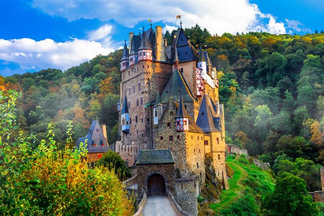 Burg Eltz castle rising from autumn forest in the Moselle hills near Cochem