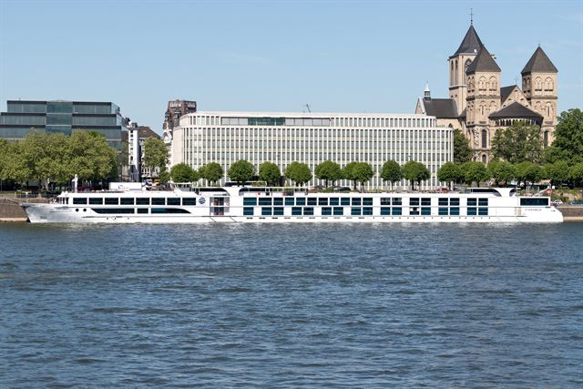 River cruise ship on the Rhine in Cologne below the Romanesque Great St. Martin Church