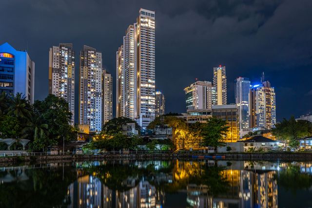 Colombo's illuminated high-rise towers reflected in Beira Lake at night