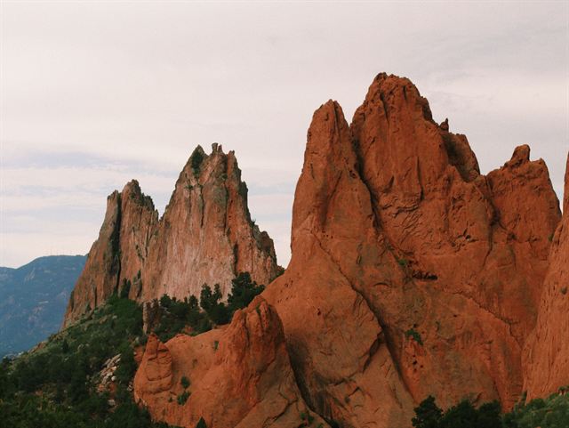 Towering red rock spires at Garden of the Gods park in Colorado Springs against a pale sky