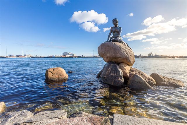 Little Mermaid bronze statue on a rock at the Copenhagen harbor waterfront