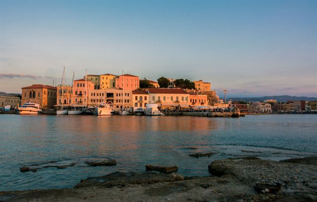 Venetian harbor of Chania, Crete, with pastel waterfront buildings lit by late sun
