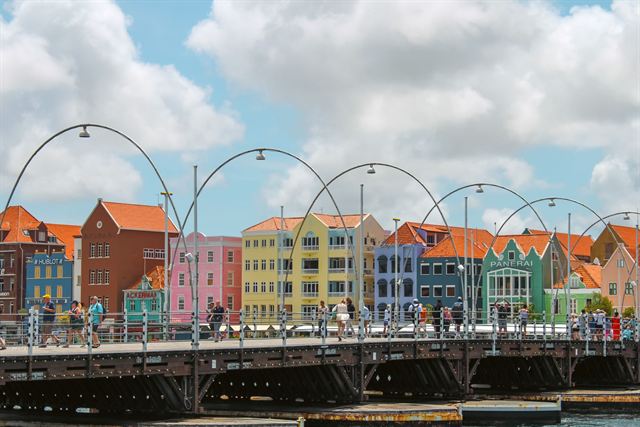 Queen Emma pontoon bridge with its arched lights crossing to the colorful Dutch gabled facades of Willemstad, Curacao