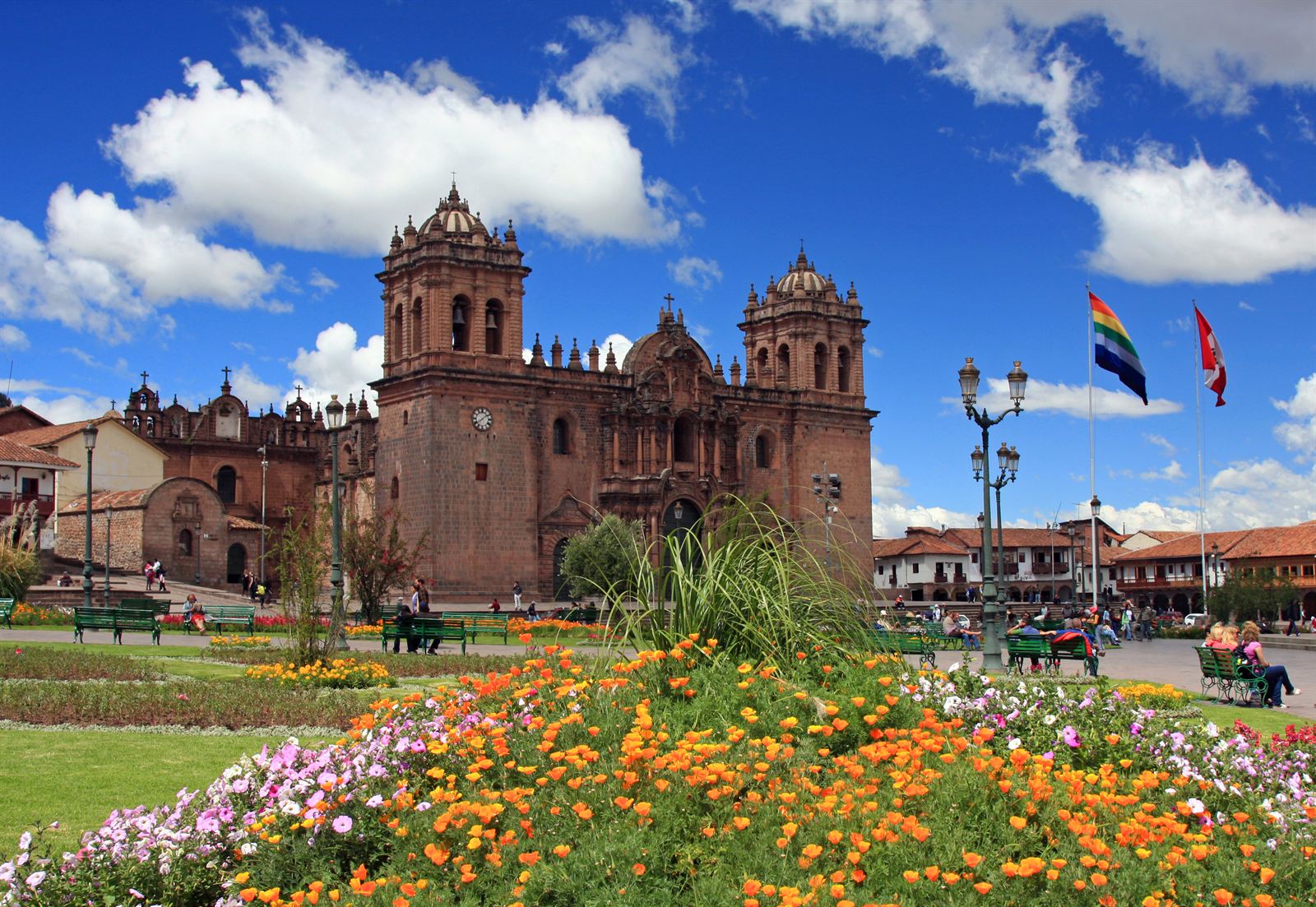 Cusco Cathedral and flower beds on the Plaza de Armas under a blue sky, Peru