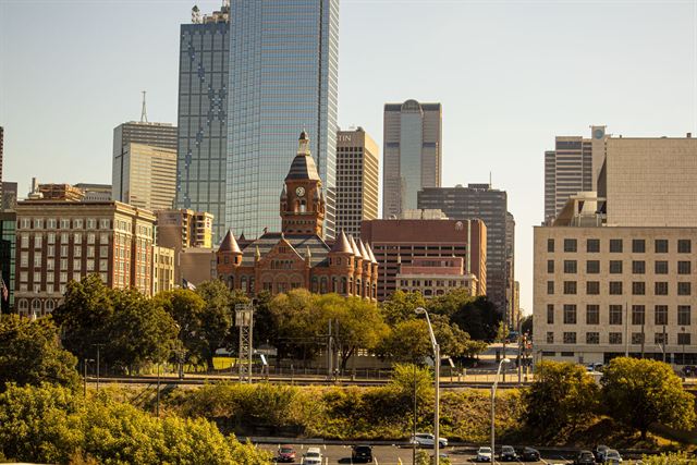 Red sandstone Old Red Museum courthouse framed by modern downtown Dallas skyscrapers