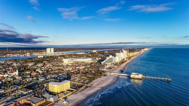 Aerial view of Daytona Beach's shoreline, fishing pier and oceanfront hotels