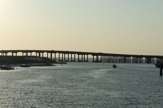 Marler Bridge spanning the East Pass at Destin with boats on the water at sunset