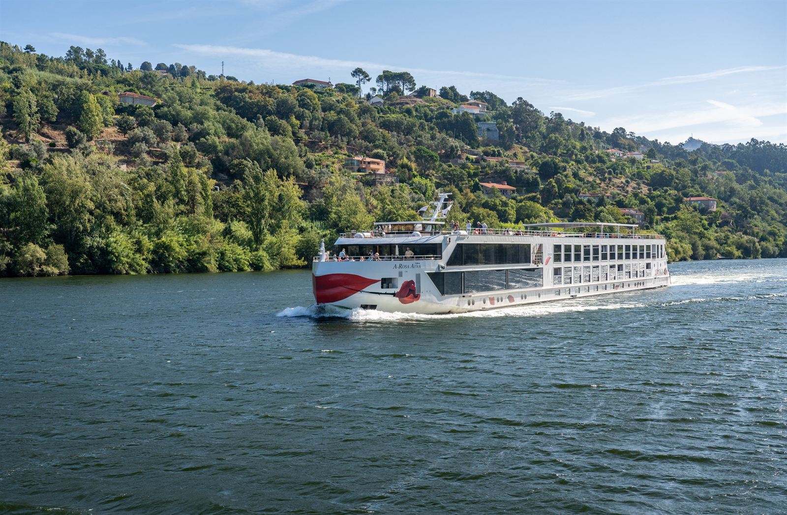 River cruise ship sailing along the Douro between wooded hills in Portugal