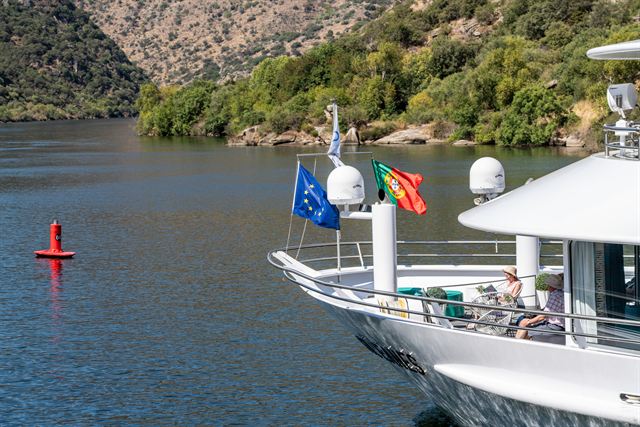 Bow of a river cruise ship flying Portuguese and EU flags on the Douro River