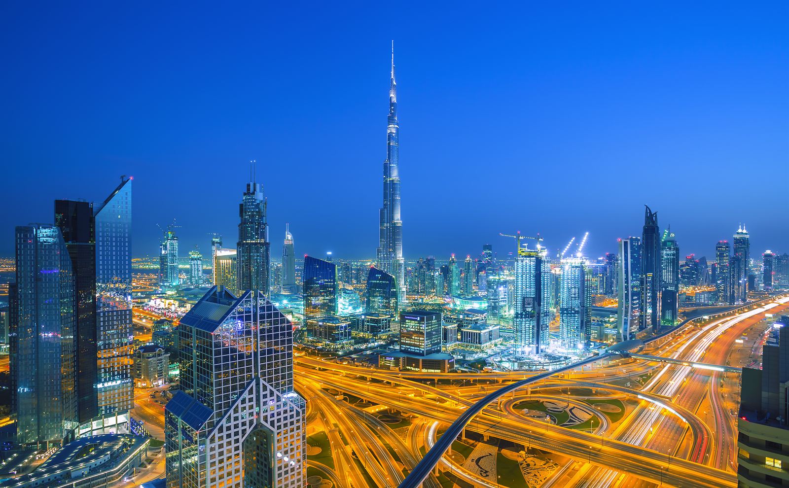 Dubai skyline at dusk with Burj Khalifa and light trails on Sheikh Zayed Road interchanges